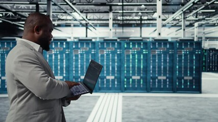 Poster - Data center developer writing code for resource optimization using notebook. Server room engineer deploying new builds to improve uptime using software on laptop, camera A