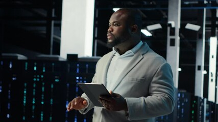 Poster - IT professional looking over data center checkup checklist paperwork on tablet. African american man walking in server farm, reading documentation files on device, camera B
