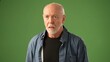© Robert Peak - A mature man wearing glasses poses thoughtfully against a solid green screen background, evoking deep contemplation and emotion in his expression.