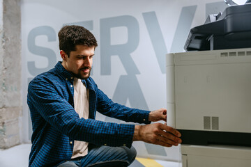 Poster - Technologist working with office printer in modern workspace on bright day