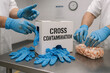© Urelzita - Cross Contamination hazard depicted with food workers handling shrimp using dirty gloves next to glove dispenser inside seafood processing area lacking hygiene control