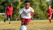 © ЮРИЙ ПОЗДНИКОВ - Young soccer player dribbling ball during training on field