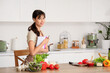 © Pixel-Shot - Young woman with recipe book and food on table in kitchen