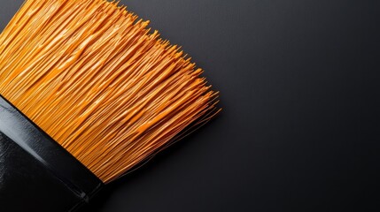 Poster - A close-up of an orange-bristle paintbrush against a dark canvas highlights the artistry and creativity involved in painting, showcasing details of color and texture interplay.