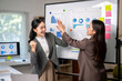 © Wasana - Businesswomen high-fiving celebrating successful corporate financial results