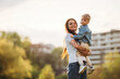 © standret - Cheerful, having fun, holding boy in hands. Mother and son are together on the summer field