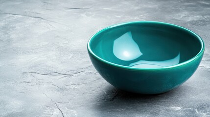 Poster - A beautifully smooth turquoise bowl stands prominently against a textured stone background, emphasizing its vibrant color and sleek design, perfect for modern decor.