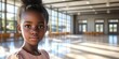© Alexander Chaykin - A young girl poses in a school library, featuring bookshelves and an interior space designed for learning and reading.
