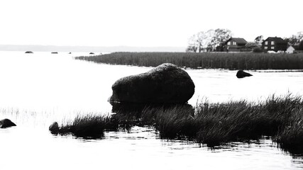 Poster - A rock submerged in calm water, providing a unique perspective