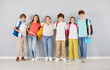 © Studio Romantic - Group portrait of happy school children in colorful clothes standing together in row and hugging each other. Joyful smiling boys and girls with backpacks looking at camera and making group photo.