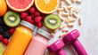 © julijadmi - Colorful assortment of fresh fruits, smoothies, and dumbbells arranged on a light surface, promoting healthy lifestyle and fitness choices