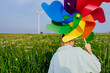 © Iryna - Teen boy with rainbow pinwheel in front of wind turbine