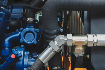 Poster - Blue engine with a black hose attached to it. The hose is connected to a black pipe
