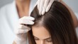© vetrana - Woman receiving hair examination by trichologist wearing gloves at a medical office for scalp health assessment
