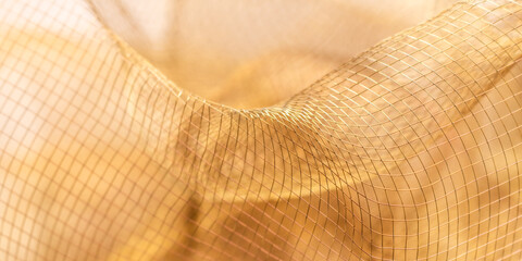 Golden Draped Mesh Fabric – Abstract Close-Up of Folded Netting with Curves and Undulating Texture in Warm Tones for Artistic and Decorative Use