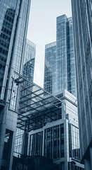 Aufkleber - Low-angle view of modern glass skyscrapers, showcasing architectural design and urban landscape, symbolizing business, progress, and modernity