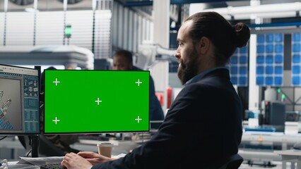 Poster - young business specialist uses computer with green screen and production metrics, overseeing the ind