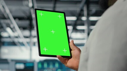 Poster - Close up of technician upgrading equipment in data center using green screen tablet. IT specialist in high tech establishment overseeing server rows with mockup device, camera B