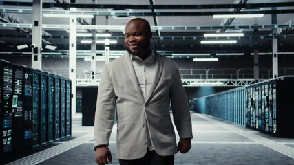Poster - Smiling employee walking in high tech data center with machines powering networks, running companies databases. Admin overseeing server farm with rigs modules processing large datasets, camera A