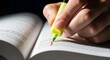 © alisya - Hand highlighting text in an open book with a bright yellow highlighter