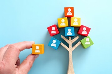 Aufkleber - Colorful wooden cubes with person icons arranged on a tree symbolize social networking, with a hand adding another cube