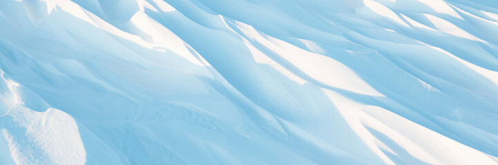 Wall Mural - Snow texture. Wind sculpted patterns on snow surface. Wind in the tundra and in the mountains on the surface of the snow sculpts patterns and ridges (sastrugi). Arctic, Polar region. Winter background