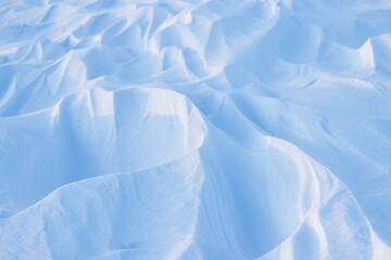Wall Mural - Snow texture. Wind sculpted patterns on snow surface. Wind in the tundra and in the mountains on the surface of the snow sculpts patterns and ridges (sastrugi). Arctic, Polar region. Winter background