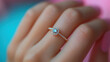 © BANDERSOUL - fine gold ring worn on hand against pastel pink and blue background
