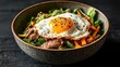 © svastix - A nutritious bowl filled with vibrant vegetables, tender beef, and a perfectly cooked sunny-side-up egg, representing a healthy and fulfilling meal that appeals to food enthusiasts.