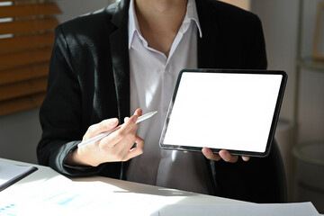 Poster - Close-up of a businessman in formal suit holding a digital tablet with blank screen and stylus in hand, ready for presentation