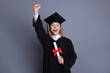 © New Africa - Happy student with diploma after graduation on grey background