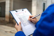 © Nattawit - A construction foreman is checking on building quality checklist report during inspecting at the house construction site (as background). Industrial working scene, close-up with selective focus.