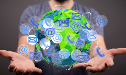 Poster - Person holding a digital globe with email, phone, and internet symbols. Global communication concept.