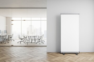 Poster - Blank vertical banner mockup standing in modern office with glass wall and wooden floor, light background for business promotion concept.