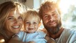 © svastix - A warm family portrait capturing a smiling mother, father, and their adorable child, basking in the sunlight that creates a joyful and loving atmosphere.