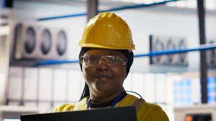 Poster - Smiling smart factory specialist testing automated systems to ensure reliability. Happy engineer in industry 4.0 industrial plant identifying bottlenecks and optimizing gear based on data, camera B