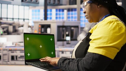 Poster - specialist using green screen laptop to conduct inspection in renewable energy industry 4.0 plant. t