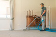 © Austockphoto - Male carpet cleaning professional using steam cleaner in home