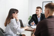 © New Africa - Couple having meeting with business consultant at table in office