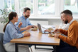 © New Africa - Colleagues eating and chatting during lunch break in office