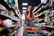© Drazen - Displeased woman with empty shopping cart at supermarket.