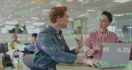 Poster - Discussing colleagues wearing blue shirt and striped blouse at office table with laptop and tablet