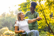 © zinkevych - Elderly person in wheelchair with caregiver in park rehab session