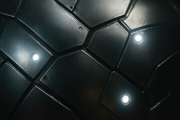 Poster - Abstract close-up of a textured black surface with geometric patterns and bright circular lights