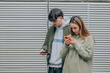 © carballo - young couple on the street with mobile phone