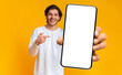 © Prostock-studio - Handsome positive man showing cellphone with white blank screen and pointing on it, posing over yellow background, mockup, closeup, selective focus
