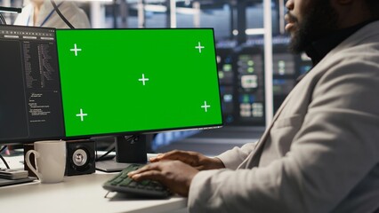 Poster - Data center admin inspecting gear using green screen mockup PC, doing maintenance tasks. African american server farm worker using chroma key computer, conducting system checks, camera A