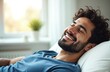 © miss irine - Happy man resting, relaxing home. Smiling guy with beard, eyes closed enjoying comfort, tranquility in modern house. Wellness, stress relief concept. Positive emotions, mental health. Indoor portrait.