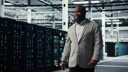 Poster - Smiling engineer walking in data center workplace with multiple rows of fully operational supercomputers. Cheerful employee overseeing server room built for digital storage systems, camera A