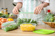 © Pixel-Shot - Woman holding plastic bag with green beans for freezing in kitchen